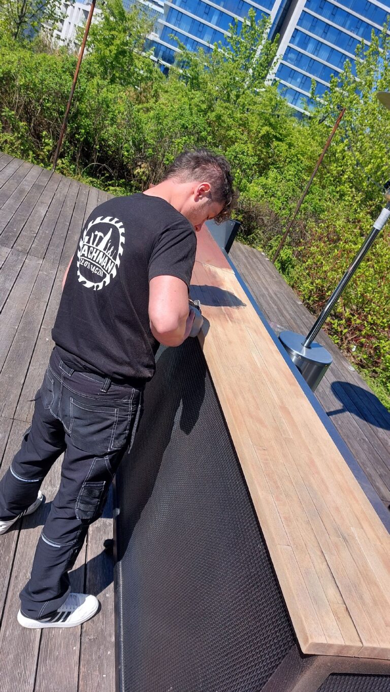 Zdjęcie pokazuje właściciela firmy szlifującego blat Ladę drewniana baru